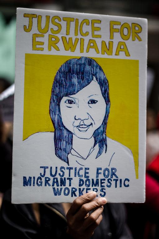 A member of a support group for Erwiana Sulistyaningsih, an Indonesian maid allegedly tortured by her Hong Kong employer, holds a placard during a rally outside the Indonesian consulate in Hong Kong on April 8, 2014