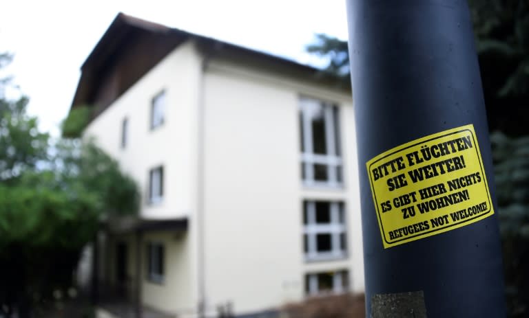 A sticker reading 'Please keep on fleeing - here is no place for you - refugees not welcome' is pinned at a lantern next to a refugee centre in Freital, eastern Germany