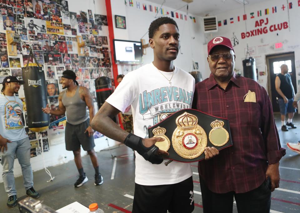 Dominique Crowder poses with his grandfather, Thomas Howard, as he holds up his championship belt during a ceremony at APJ Boxing in Poughkeepsie Aug. 23, 2023. Crowder, a former Poughkeepsie resident, won the WBA bantamweight international title earlier this month and he was celebrated in a ceremony by the gym that first trained him.