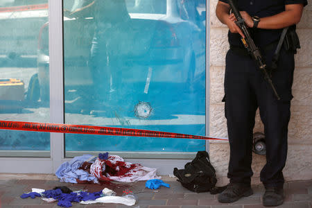 Blood-stained clothes and a bullet hole in a glass panel are seen at the scene of a stabbing attack near a mall in the Gush Etzion Junction in the occupied West Bank, September 16, 2018. REUTERS/Ronen Zvulun