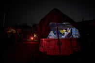 Karmat Singh, 62, right, and Joginder Singh, 77, pray inside their tractor trailer parked on a highway as they join a protest against new farm bills, at the Delhi-Haryana state border, India, Wednesday, Dec. 2, 2020. The convoy of trucks, trailers and tractors stretches for at least three kilometers (1.8 miles) with farmers who have hunkered down, supplied with enough food and fuel to last weeks. Their rallying call is “Inquilab Zindabad” (“Long live the revolution”). (AP Photo/Altaf Qadri)