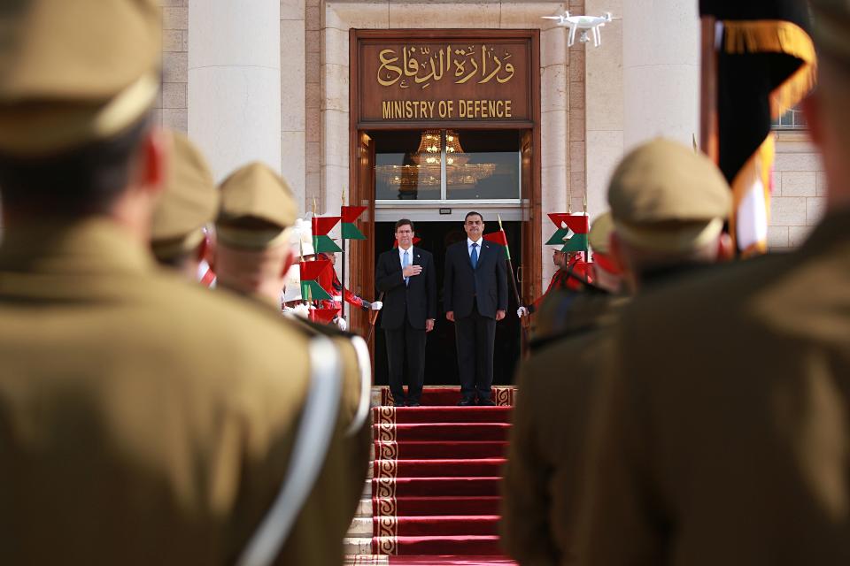 Iraqi Defense Minister Najah al-Shammari, center right, and U.S. Defense Secretary Mark Esper, center left, stand for their country's national anthems during a welcome ceremony at the Ministry of Defense, Baghdad, Iraq, Wednesday, Oct. 23, 2019. Esper has arrived in Baghdad on a visit aimed at working out details about the future of American troops that are withdrawing from Syria to neighboring Iraq. (AP Photo/Hadi Mizban)