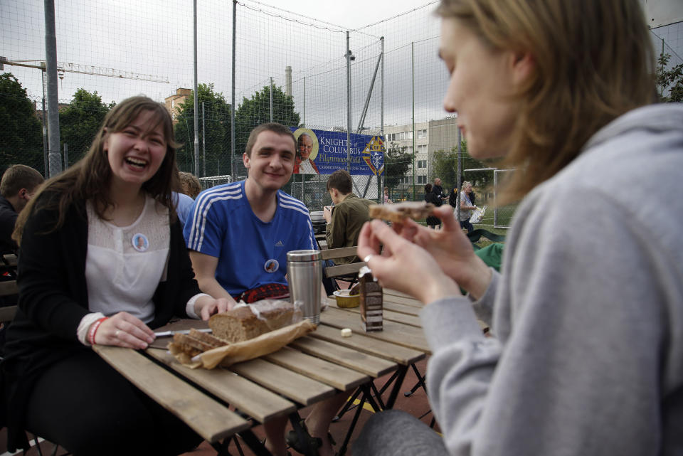 Polish pilgrims enjoy their breakfast at a tented camp set up at the Knights Columbus sports grounds in Rome, Saturday, April 26, 2014. Hundred thousands of pilgrims and faithful are expected to reach Rome to attend the scheduled April 27 ceremony at the Vatican in which Pope Francis will elevate in a solemn ceremony John XXIII and John Paul II to sainthood. (AP Photo/Gregorio Borgia)