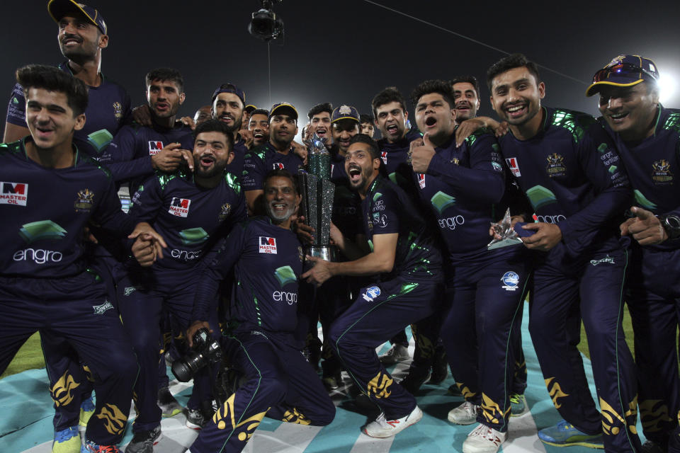 Players and officials of Quetta Gladiator pose for photograph with trophy after won the final cricket match of Pakistan Super League against Peshawar Zalmi at National stadium in Karachi, Pakistan, Sunday, March 17, 2019. (AP Photo/Fareed Khan)