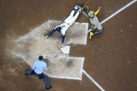 Milwaukee Brewers' Brice Turang slides safely past San Diego Padres catcher Kyle Higashioka during the eighth inning of a baseball game Wednesday, April 17, 2024, in Milwaukee. (AP Photo/Morry Gash)