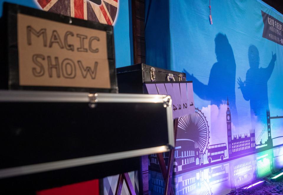 A shadow of Sarah Harfield, aka Lady Sarah, is seen on a blue backdrop as she talks in front of a large audience during the Magic Soiree inside Camp Ticonderoga in Troy on Saturday, Sept. 30, 2023.