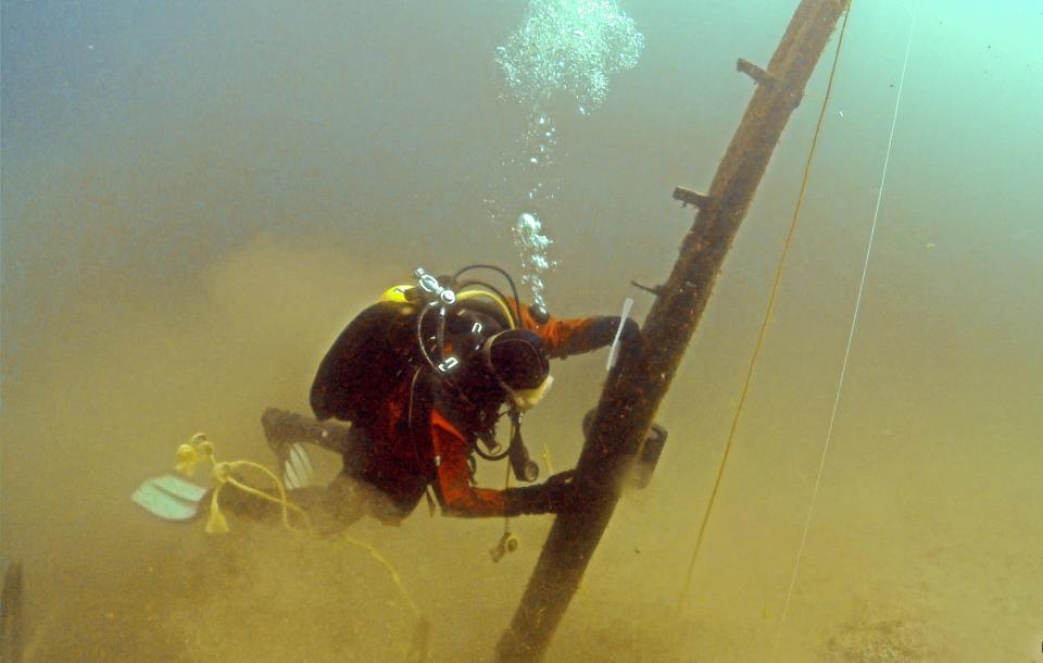 In this June 16, 2013 file photo provided by Great Lakes Exploration Group, diver Jim Nowka of Great Lakes Exploration Group inspects a wooden beam extending from the floor of Lake Michigan that experts believe may be part of the Griffin, a ship that sank in 1679. The timber has been examined by U.S. and French experts and underwent a hospital CT scan and carbon dating to determine its age and whether it once was part of a vessel. Nearly a year later, reports obtained by The Associated Press and interviews with key players reveal sharp divisions over whether the elusive ship has been found. (AP Photo/Great Lakes Exploration Group, David J. Ruck, File)