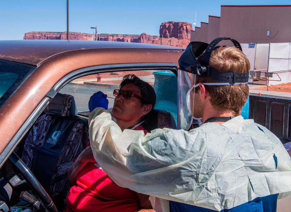 A nurse takes a swab sample from a Navajo Indian woman complaining of virus symptoms at a COVID-19 testing center at the Navajo Nation town of Monument Valley in Arizona in May 2020.