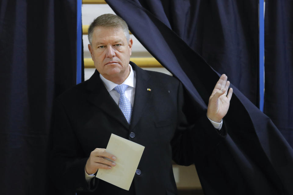 Romanian President Klaus Iohannis exits a voting cabin in Bucharest, Romania, Sunday, Nov. 24, 2019. Romanians are voting in a presidential runoff election in which incumbent Klaus Iohannis is vying for a second term, facing Social Democratic Party leader Viorica Dancila, a former prime minister, in Sunday's vote. (AP Photo/Vadim Ghirda)