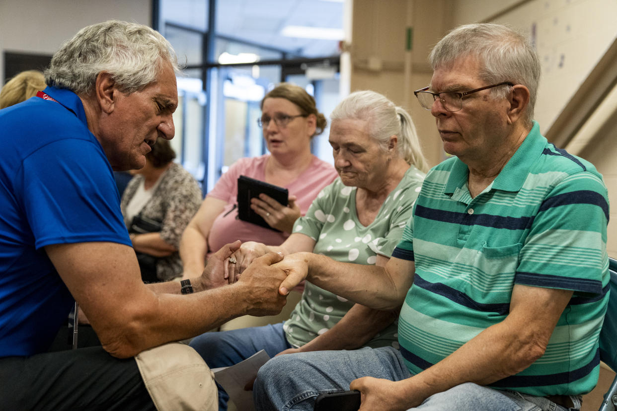 Image: Ronnie and Sue Combs pray in the Knott County Sportsplex on Aug. 2, 2022. (Michael Swensen for NBC News)