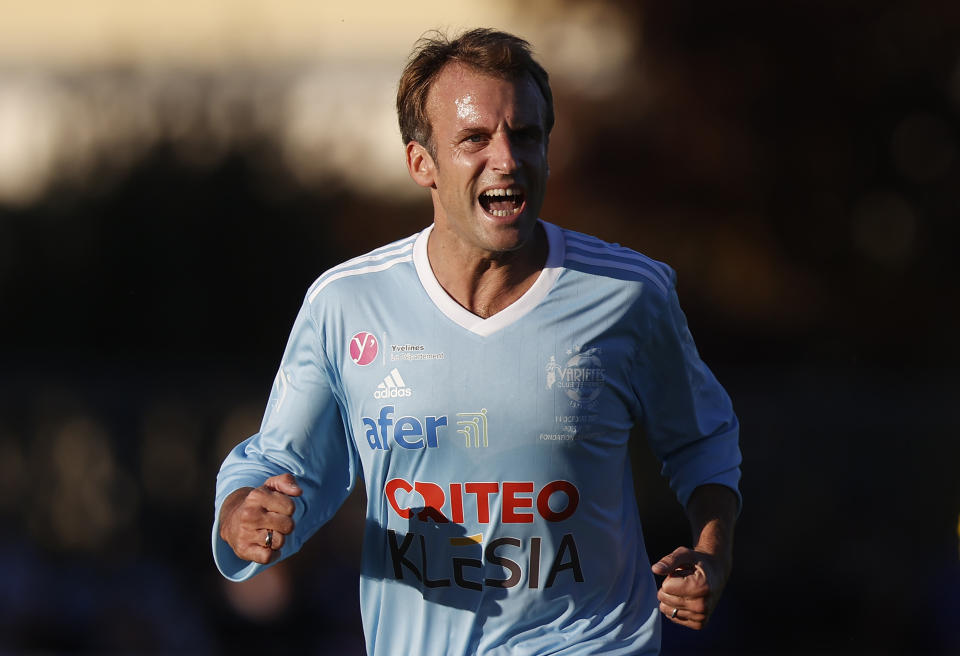 FILE - French President Emmanuel Macron reacts as he plays in the Varietes Club gala football match marking the club's 50th anniversary, in Leo Lagrange stadium, Thursday, Oct. 14, 2021 in Poissy, outside Paris. (Ian Langsdon, Pool Photo via AP, File)