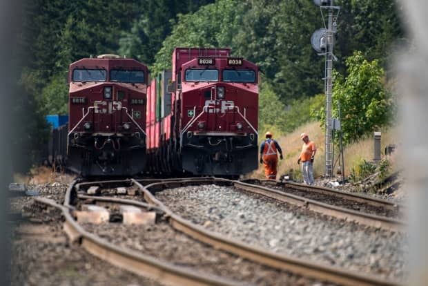 Rail lines owned by CN and CP were damaged by wildfires in B.C. last month, and that has caused their entire networks to face bottlenecks.   (James MacDonald/Bloomberg - image credit)