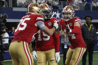 San Francisco 49ers wide receiver Deebo Samuel, middle, is congratulated by tight end George Kittle (85) and fullback Kyle Juszczyk (44) after scoring against the Dallas Cowboys during the second half of an NFL wild-card playoff football game in Arlington, Texas, Sunday, Jan. 16, 2022. (AP Photo/Roger Steinman)