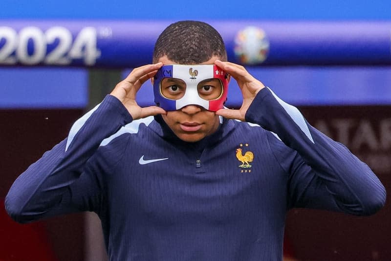 France's Kylian Mbappe adjusts his mask during a training session ahead of Friday's UEFA Euro 2024 Group D soccer match between the Netherlands and France. Jan Woitas/dpa