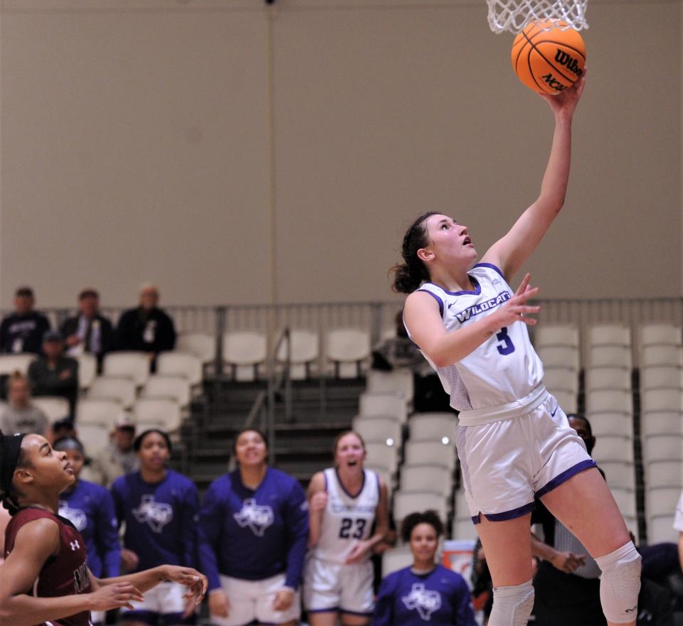 ACU's Bella Earle, right, drives to the basket as a New Mexico State defender looks on. Earle's score pulled the Wildcats within one (71-70) with 1:59 left in the game.