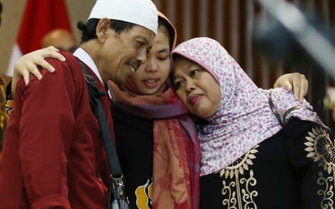 Siti Aisyah hugs here relieved father, Asria, and mother, Binah - Credit: Achmad Ibrahim/AP