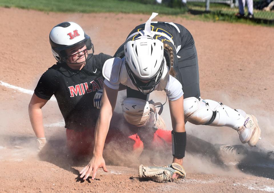 Reese Knox of Milan scores in the first inning as the ball thrown home was wide to the catcher Payton Zajac of Airport Tuesday, April 30, 2024 as Milan won the Huron League match-up 10-6.