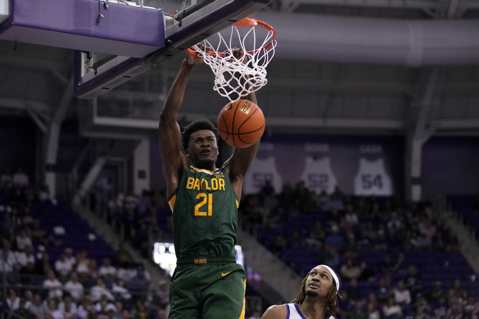 Baylor center Yves Missi (21) dunks over TCU forward Xavier Cork, bottom, in the second half of an NCAA college basketball game in Fort Worth, Texas, Monday, Feb. 26, 2024. (AP Photo/Tony Gutierrez)