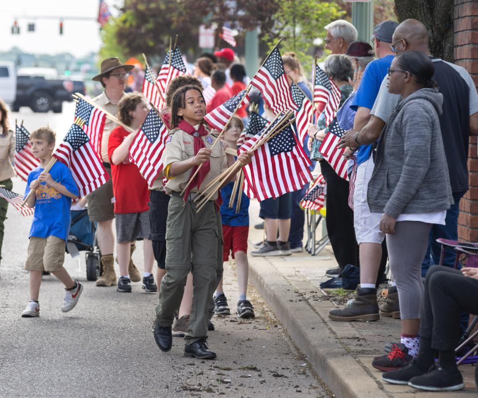 Ruben Chaney and Boy Scouts pass out flags along the route of Canton’s Memorial Day parade.