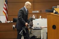 Assistant State Attorney Mike Satz handles the gun used by Marjory Stoneman Douglas High School shooter Nikolas Cruz during the penalty phase of Cruz's trial at the Broward County Courthouse in Fort Lauderdale, Fla., on Tuesday, July 26, 2022. Cruz previously plead guilty to all 17 counts of premeditated murder and 17 counts of attempted murder in the 2018 shootings. (Mike Stocker/South Florida Sun Sentinel via AP, Pool)