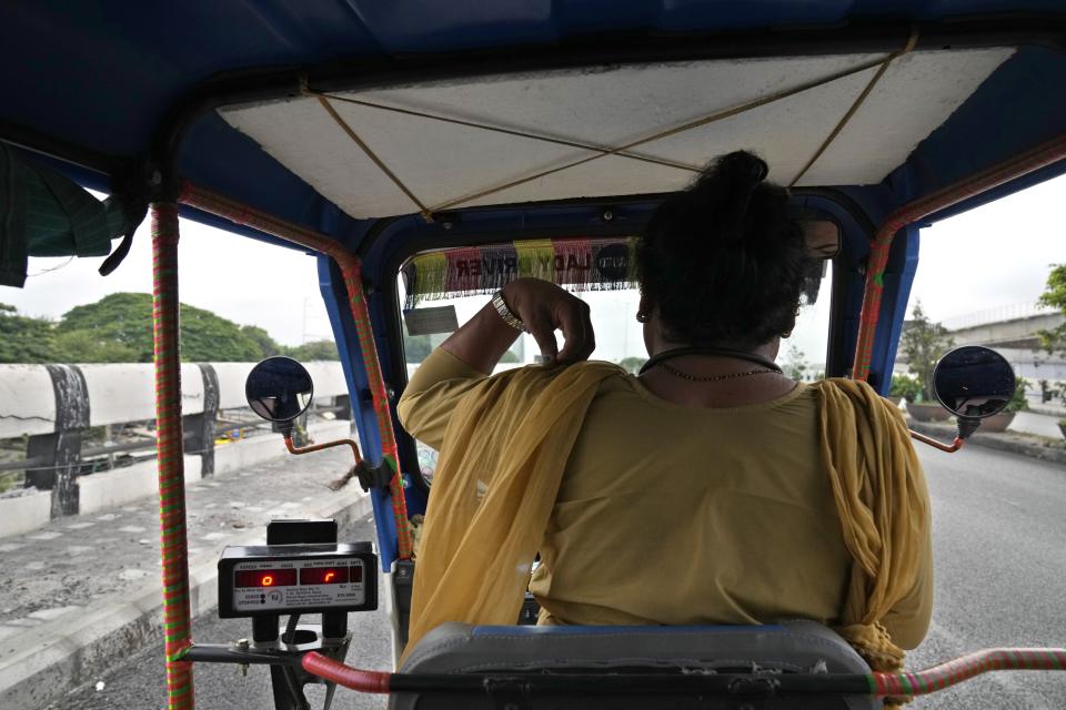 Preethi, a 38-year-old transgender woman who uses only her first name, rides her electric auto rickshaw looking for passengers in Bengaluru, India, Monday, July 10, 2023. She's now one of millions of electric vehicle owners in India, but one of very few to have received an EV through a charitable donation. (AP Photo/Aijaz Rahi)