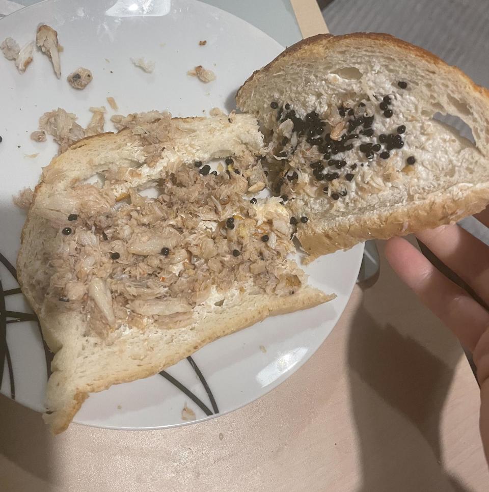 two slices of white bread with crab meat, caviar, and mayo in it