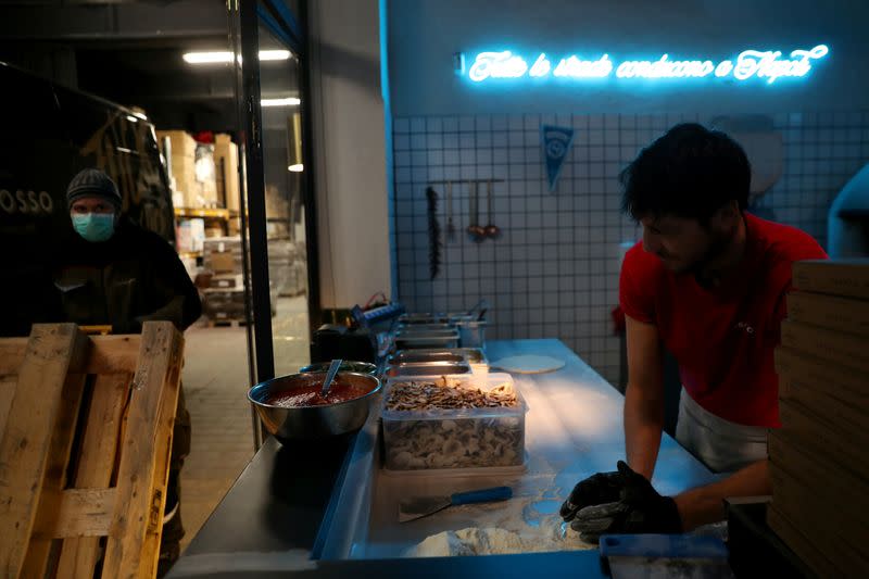 Flavio Russo prepares some of the 40 pizzas that Grosso Napoletano restaurant donates daily to medical staff at hospitals as part of the Food4Heroes initiative during the outbreak of coronavirus disease (COVID-19) in Madrid