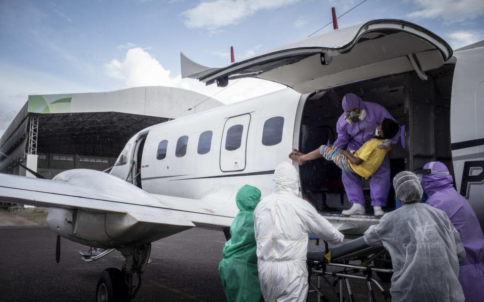 Medical workers in Manuas unload a 10-year old patient from the remote Amazonas settlement of San Antonio del Ica on 22 May - RAPHAEL ALVES/Shutterstock