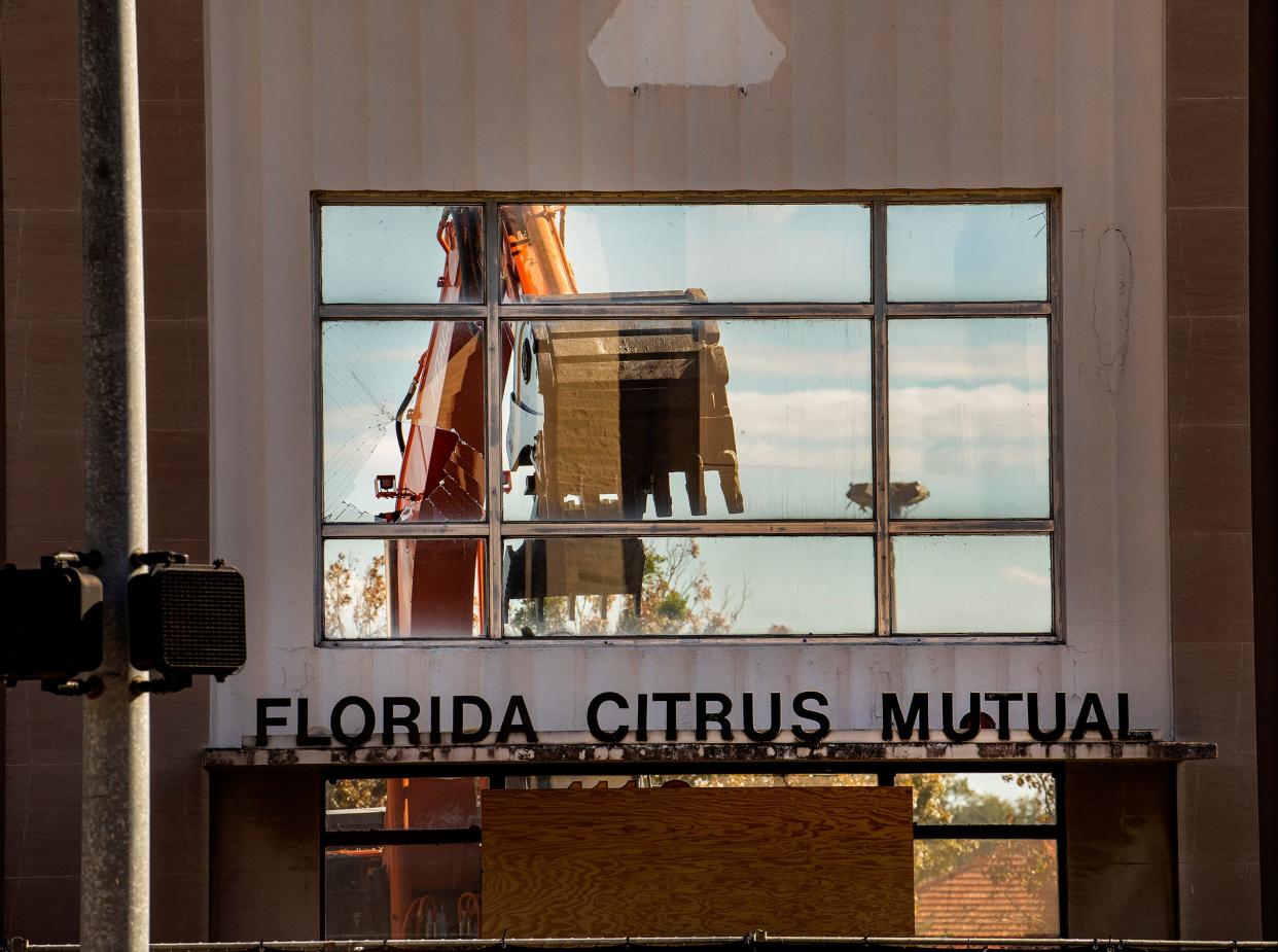 An excavator is seen through the front windows of the Florida Citrus Mutual building during demolition at Orange Street and Massachusetts Avenue in Lakeland on Thursday. Publix Super Markets Inc., which now owns the building got approval in August to demolish the building for a parking lot serving the company's planned IT campus, which will take up two large buildings on nearby blocks.