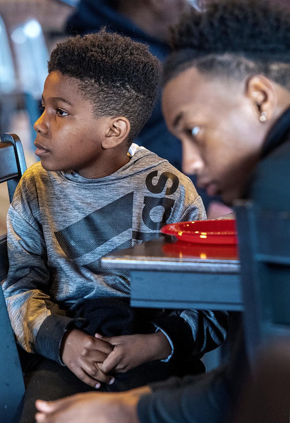 Brothers Kasen Hennesee, 9, left, and Keni Foster, listen to the story of their grandfather, legendary basketball player Henry Logan March 14, 2023 in Asheville. "His story influences me to keep pushing for my goals,” said Foster, “He created a pathway for a lot of us.”