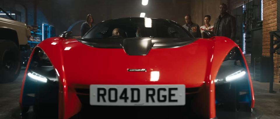 A license plate on a shiny red car reads "R04D RGE" in the movie "Fast X."