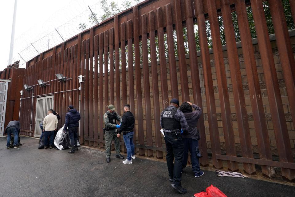 Federal officers remove handcuffs from men before releasing them through a gate in a border wall to Tijuana, Mexico, on March 15, 2023, in San Diego. The Biden administration will open migration centers in South and Central America for asylum-seekers heading to the U.S.-Mexico border in a bid to slow what’s expected to be a surge of migrants seeking to cross the border next month as pandemic-era immigration restrictions end, U.S. officials said Thursday, April 27, 2023.