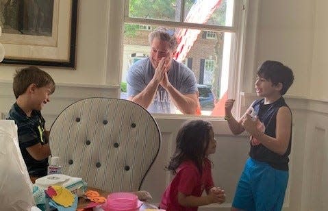 Sean Tracey leans against the glass while visiting his grandkids at their Houston home in March 2020. (From left) Ander Walters 6, and Jackie Walters, 4, and Rory Walters, 8. The family rides together in his 1968 Ford Bronco, which has been restored to a modern standard.