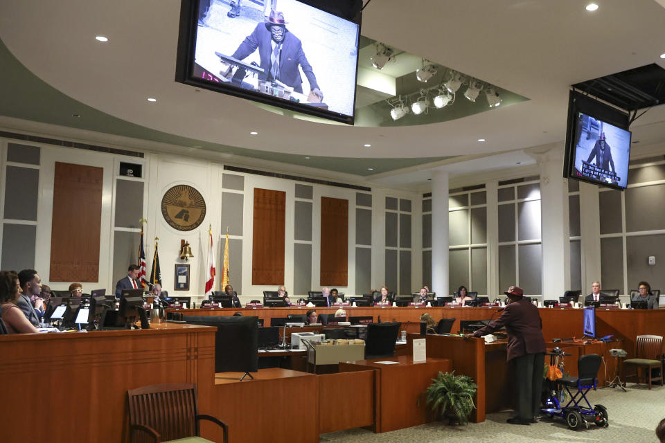 Ben Frazier, president of the Northside Coalition of Jacksonville, shown in multiple video screens, speaks to the Jacksonville City Council in Jacksonville, Fla., Jan. 18, 2023. A protracted legal fight over how city council districts were drawn in Jacksonville, Florida, reflects an aspect of redistricting that often remains in the shadows. Political map-drawing for congressional and state legislative seats captures wide attention after new census numbers are released every 10 years. No less fierce are the battles over the way voting lines are drawn in local governments, for city councils, county commissions and even school boards.(AP Photo/Gary McCullough)