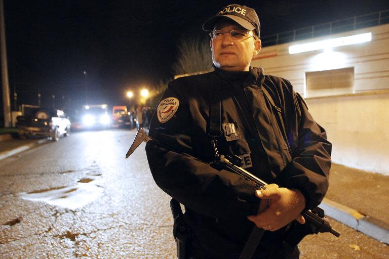 A policeman stands guard as police and firefighters hunt for a tiger on the loose in Montevrain, near Paris, on November 13, 2014