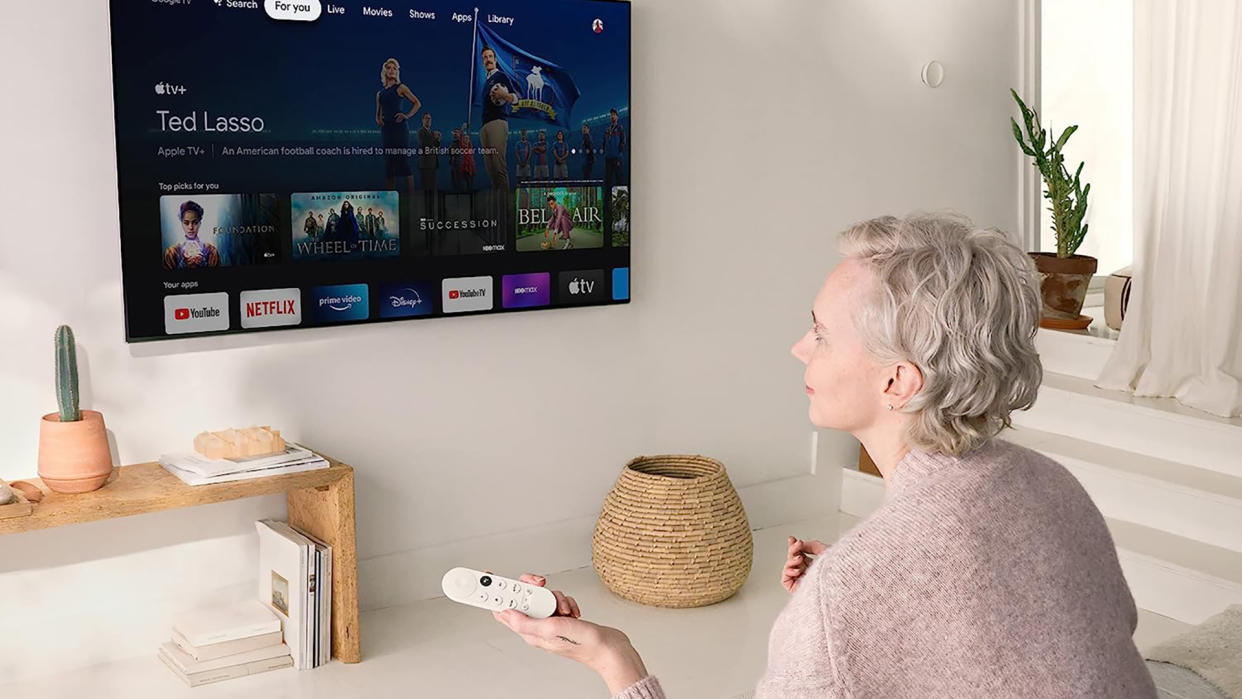  Chromecast with Google TV being used by woman. 