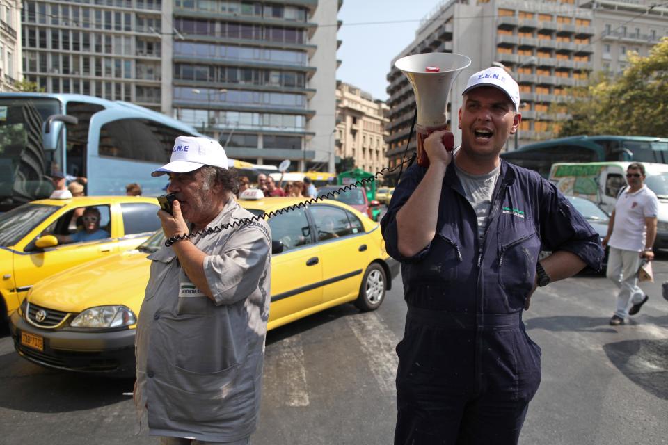 Striking shipyard workers chant slogans as they block the street during a protest demanding jobs in their sector, outside the Greek Finance ministry in Athens on Tuesday, July 10, 2012. Greece has had to impose harsh austerity measures, including big cuts to pensions and salaries, to secure billions of euros worth of rescue loans from the IMF and other European countries that use the euro, to avoid bankruptcy.(AP Photo/Petros Giannakouris)