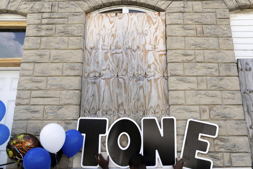 Friends and family of Antonio Lee set up a vigil for Lee, Friday, Aug. 18, 2023, in Baltimore. Lee, 19, was shot and killed while squeegeeing in Baltimore. (AP Photo/Julia Nikhinson)