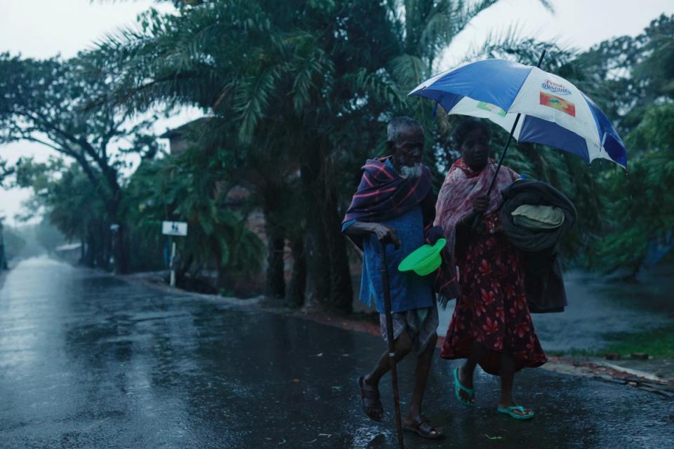 People move with their belongings to the cyclone shelter before Cyclone Remal in Satkhira (Reuters)