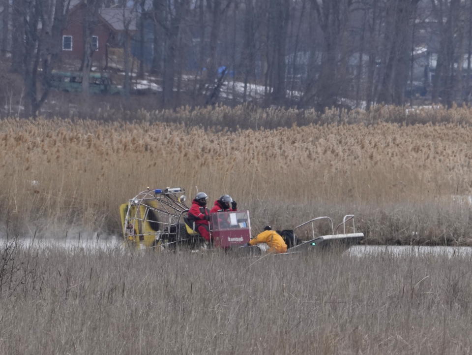 Rescuers search an area in Akwesasne, Quebec, Friday, March 31, 2023. Authorities in the Mohawk Territory of Akwesasne said Friday one child is missing after the bodies of six migrants of Indian and Romanian descent were pulled from a river that straddles the Canada-U.S. border. (Ryan Remiorz/The Canadian Press via AP)