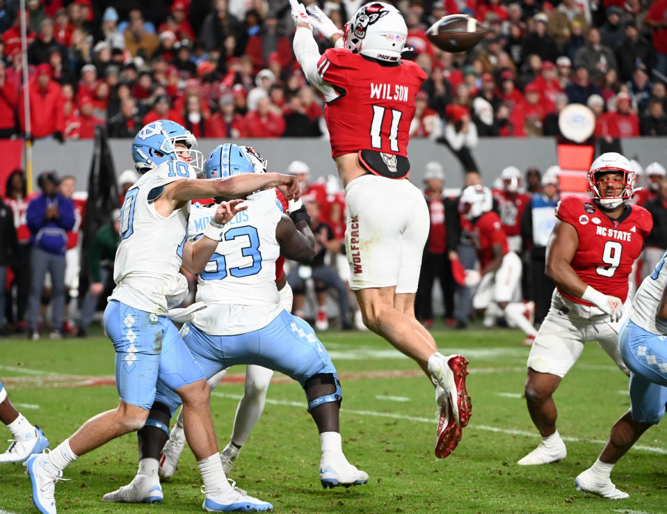 Nov 25, 2023; Raleigh, North Carolina, USA; North Carolina Tar Heels quarterback <a class="link " href="https://sports.yahoo.com/ncaaf/players/322656/" data-i13n="sec:content-canvas;subsec:anchor_text;elm:context_link" data-ylk="slk:Drake Maye;sec:content-canvas;subsec:anchor_text;elm:context_link;itc:0">Drake Maye</a> (10) throws a pass against North Carolina State Wolfpack linebacker <a class="link " href="https://sports.yahoo.com/ncaaf/players/286737/" data-i13n="sec:content-canvas;subsec:anchor_text;elm:context_link" data-ylk="slk:Payton Wilson;sec:content-canvas;subsec:anchor_text;elm:context_link;itc:0">Payton Wilson</a> (11) during the first half at Carter-Finley Stadium. Mandatory Credit: Rob Kinnan-USA TODAY Sports