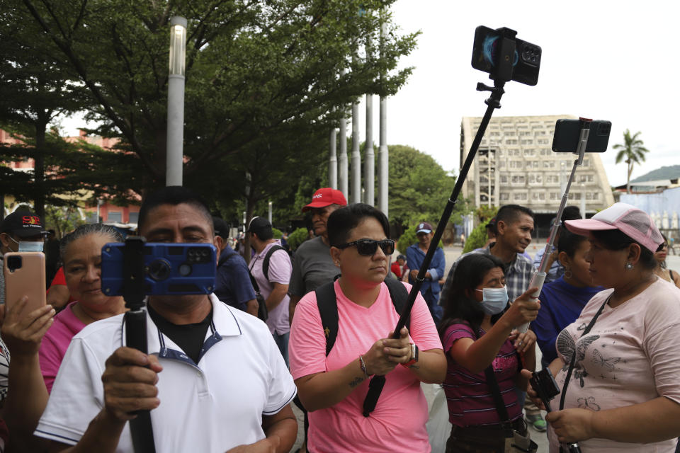 People film with their mobile devices at Plaza Libertad in San Salvador, El Salvador, Saturday, June 24, 2023. In April, the President of El Salvador’s congress Ernesto Castro announced he would open the legislative body to YouTubers and social media content creators so they could “inform with objectivity”. (AP Photo/Salvador Melendez)