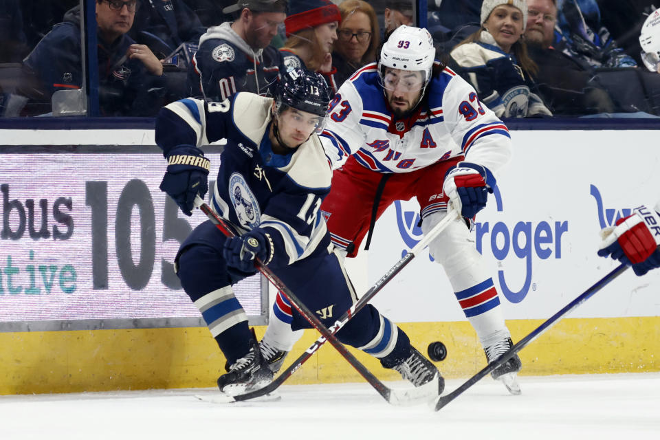 Columbus Blue Jackets forward Johnny Gaudreau, left, passes in front of New York Rangers forward Mika Zibanejad during the first period of an NHL hockey game in Columbus, Ohio, Sunday, Feb. 25, 2024. (AP Photo/Paul Vernon)