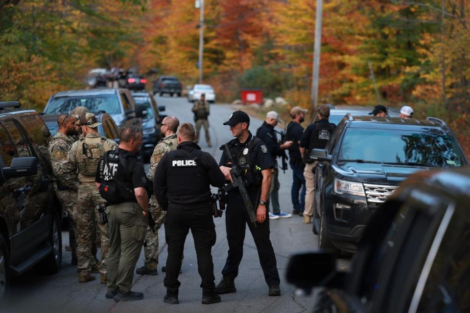 Law enforcement officials gather in the road leading to the home of the suspect on Thursday (Getty Images)