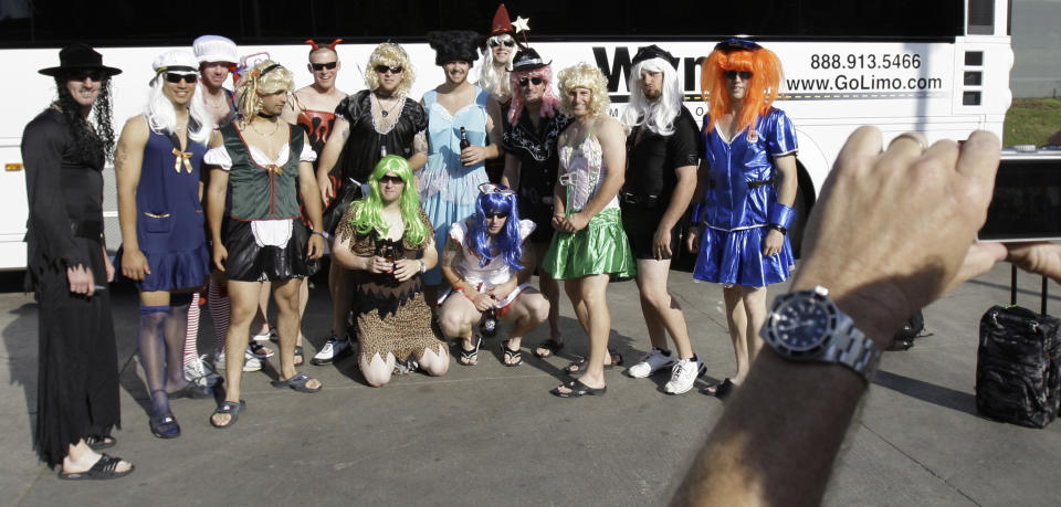 FILE - In this Sept. 24, 2008, file photo, Oakland Athletics rookie players dressed in costumes line up for a group photo before boarding the team bus after their 14-4 loss to the Texas Rangers, in Arlington, Texas. That hazing ritual of dressing up rookies as Wonder Woman, Hooters Girls and Dallas Cowboys cheerleaders is now banned. Major League Baseball created an Anti-Hazing and Anti-Bullying Policy that covers the practice. As part of the sport's new labor deal, set to be ratified by both sides Tuesday, Dec. 12, 2016 the players' union agreed not to contest it. (AP Photo/LM Otero, File)
