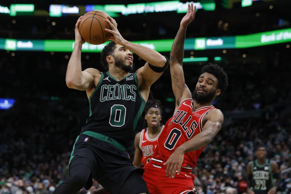 Boston Celtics' Jayson Tatum, left, shoots against Chicago Bulls' Coby White during the second half of an NBA basketball game, Saturday, Jan. 15, 2022, in Boston. (AP Photo/Michael Dwyer)