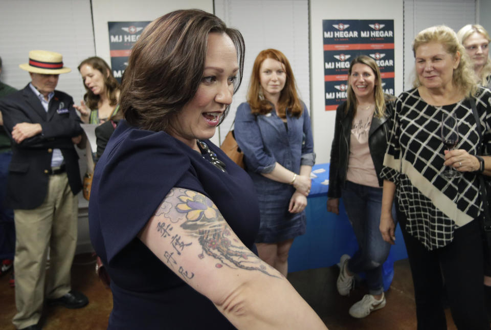 Democratic U.S. Senate candidate MJ Hegar shows her tattoo to supporters during her election night party in Austin, Texas, Tuesday, March 3, 2020. (AP Photo/Eric Gay)