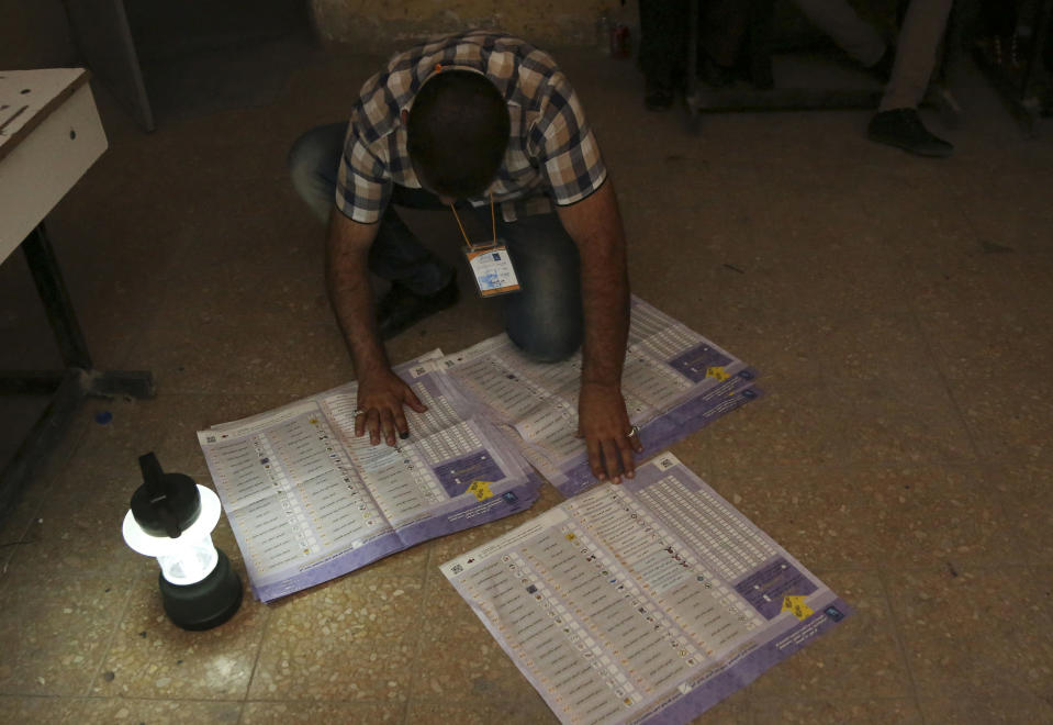 An electoral worker counts ballots under lamplight, due to a power cut, as polls close at a polling center in Baghdad, Iraq, Wednesday, April 30, 2014. Iraqis braved the threat of bombs and other violence to vote Wednesday in parliamentary elections amid a massive security operation as the country slides deeper into sectarian strife. (AP Photo/Karim Kadim)