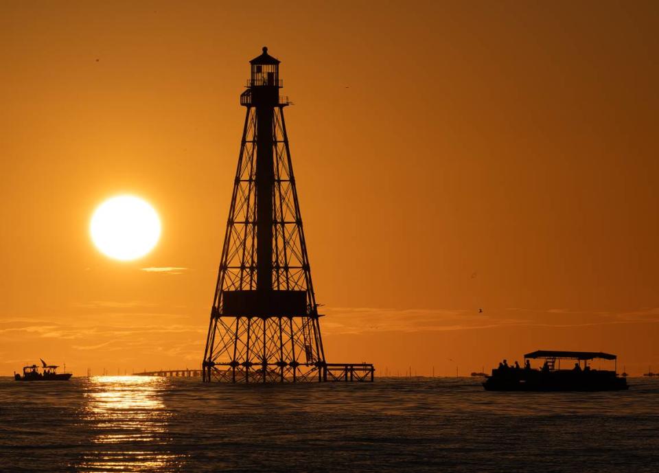 Boaters watch a sunset behind Alligator Reef Lighthouse Friday, Oct. 6, 2023, off Islamorada in the Florida Keys.