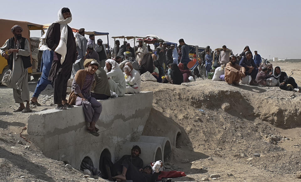 Stranded people gather and wait to open the border which was closed by authorities, in Chaman, Pakistan, Saturday, Aug. 7, 2021. Chaman border crossing is one of busiest border crossings between Pakistan and Afghanistan. Thousands of Afghans and Pakistanis cross daily and a steady stream of trucks passes through, taking goods to land-locked Afghanistan from the Arabian Sea port city of Karachi in Pakistan. (AP Photo/Tariq Achakzai)